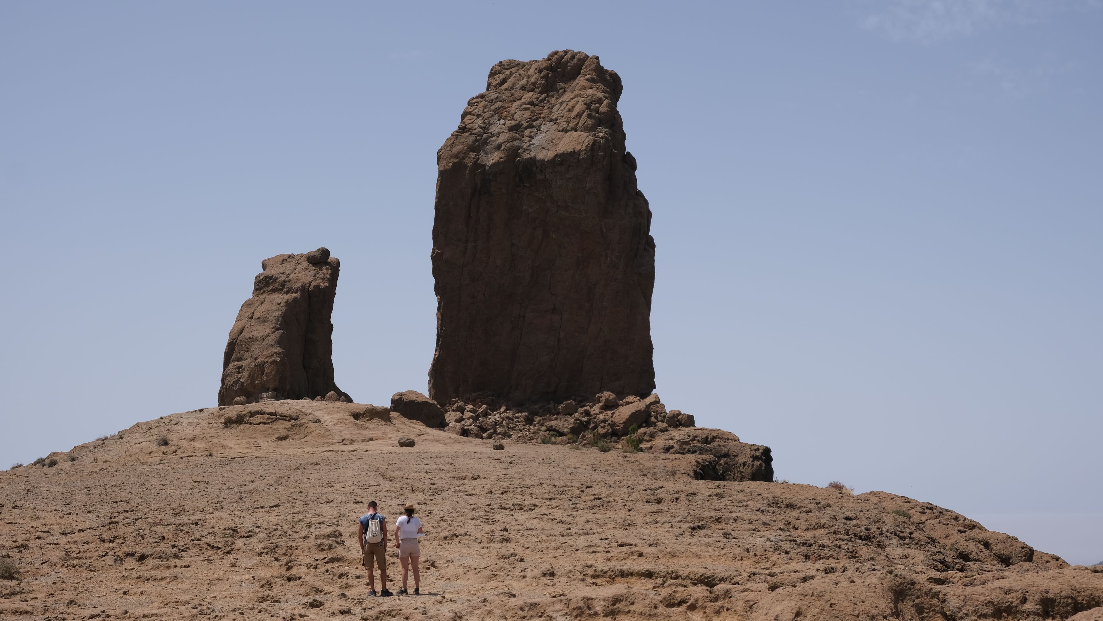 Two walkers beneath the Roque Nublo monolith
